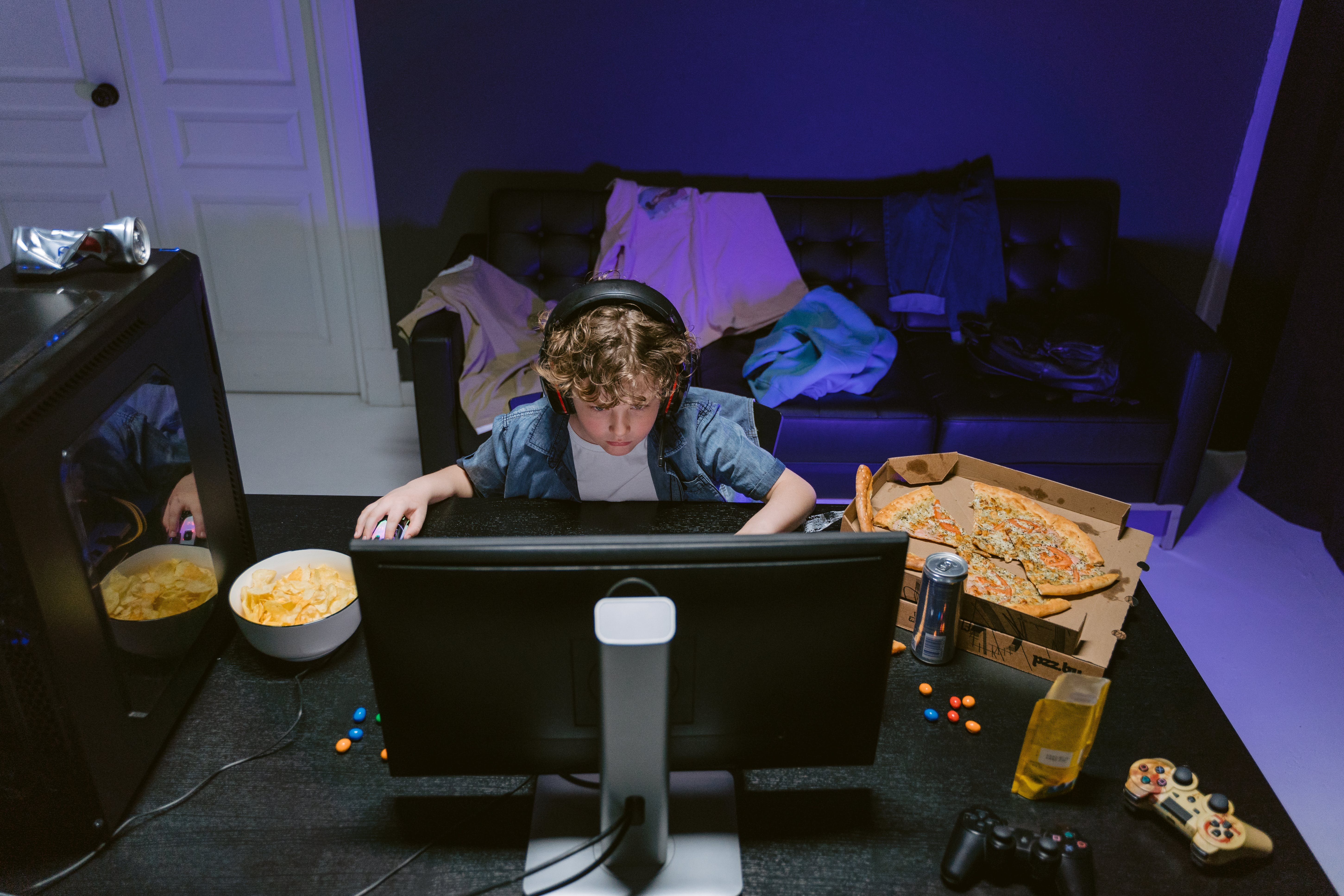 child playing video games with a variety of snacks